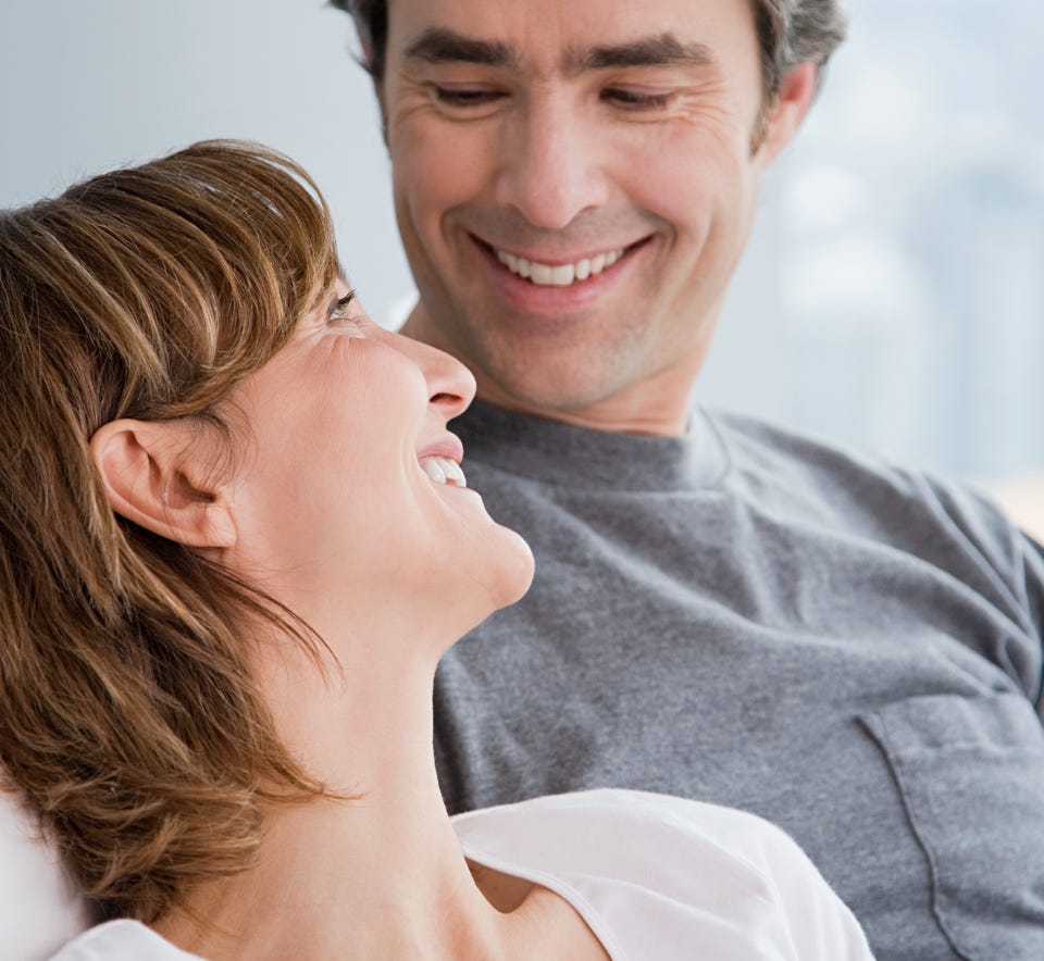 Thema Beziehung: Ein Mann und eine Frau sitzen zusammen und lächeln sich an.